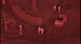 An aerial view of a group of people walking down a street.