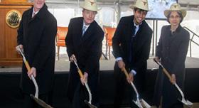 A group of men in suits and hats with shovels.