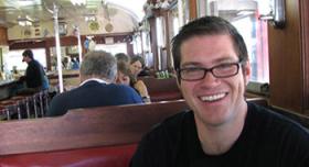 A man smiling in a diner.