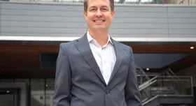 A man in a suit standing in front of a building.