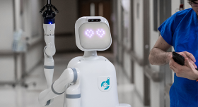 A nurse is standing next to a robot in a hospital hallway.