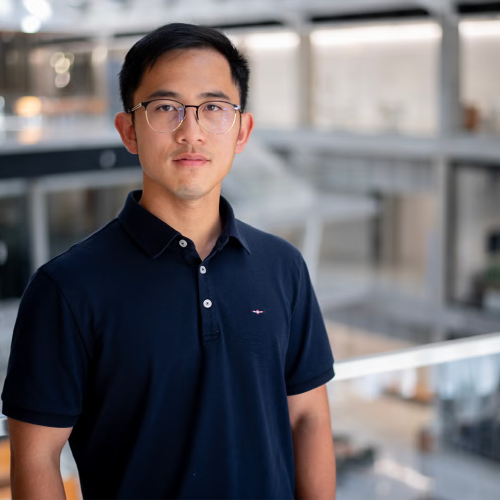 Man with glasses standing in front of railing