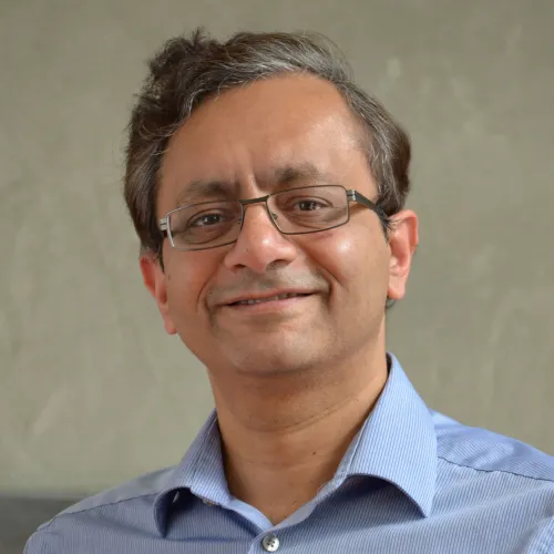 A man wearing glasses and a blue shirt.